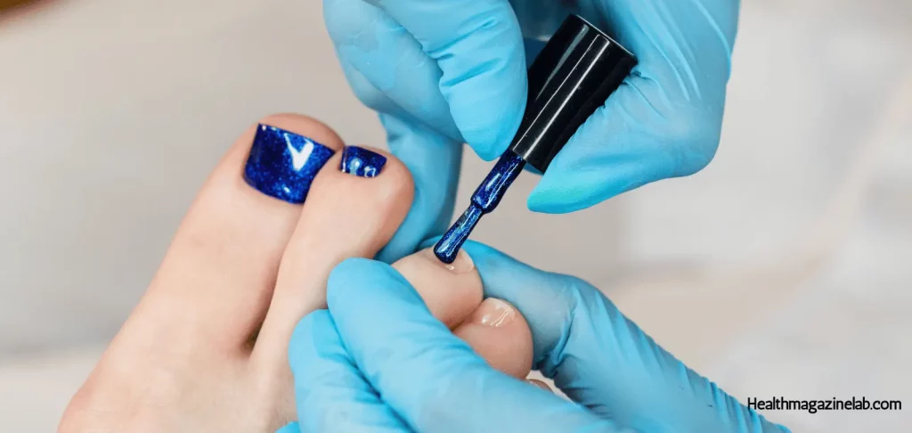 a person applying a gel top coat on their nails.